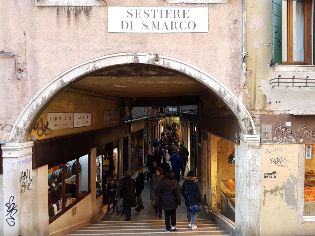 Menschen gehen durch einen Torbogen in einem Einkaufszentrum in der Unterkunft Casanova Apartment in Venedig