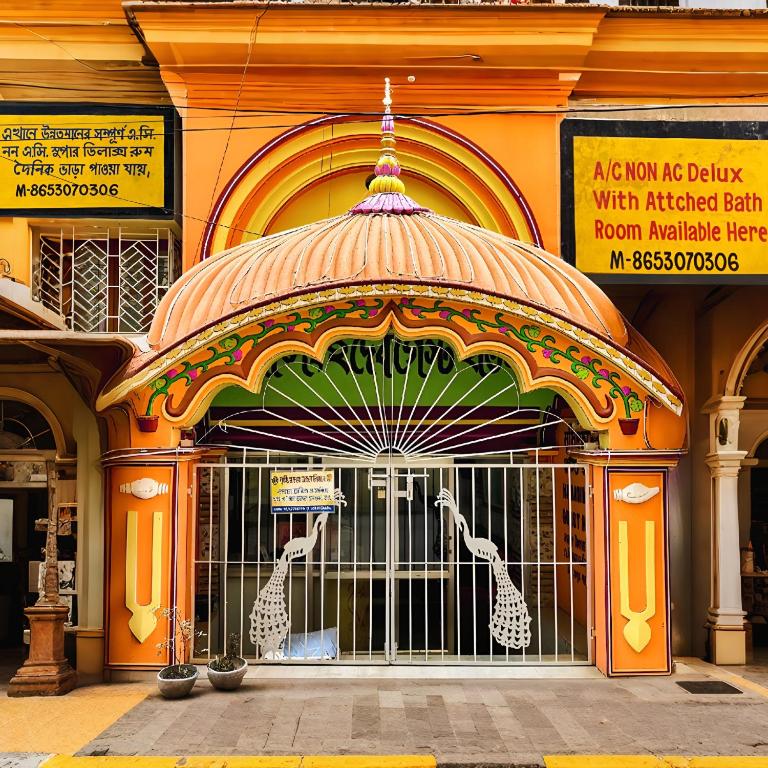 a building with a gate with giraffes on it at Narasimha Dev Guest House in mayapur