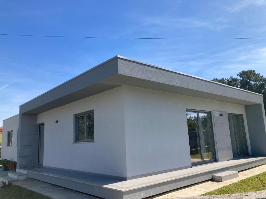 a white house with a gray roof at Casa Alex in Arão
