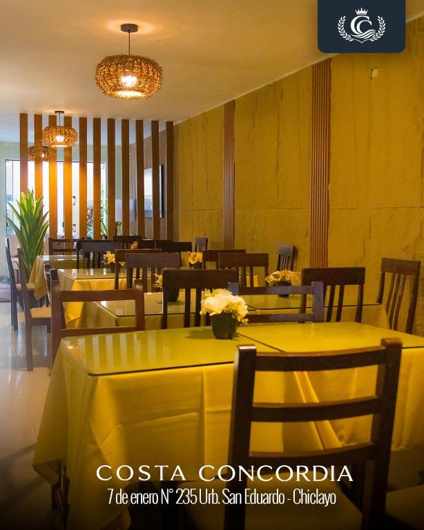 a restaurant with yellow tables and chairs and a chandelier at Costa Concordia in Chiclayo