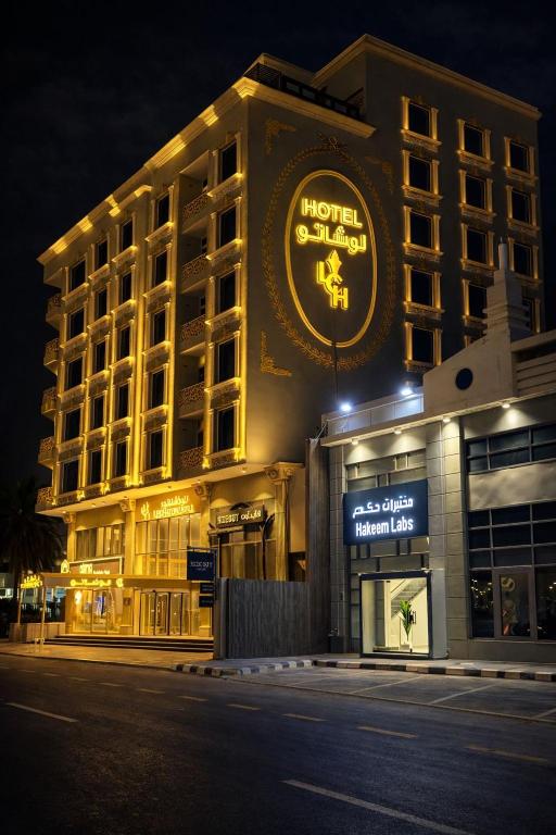 a hotel building with a sign on it at night at LeChateau Boutique Hotel in Jeddah