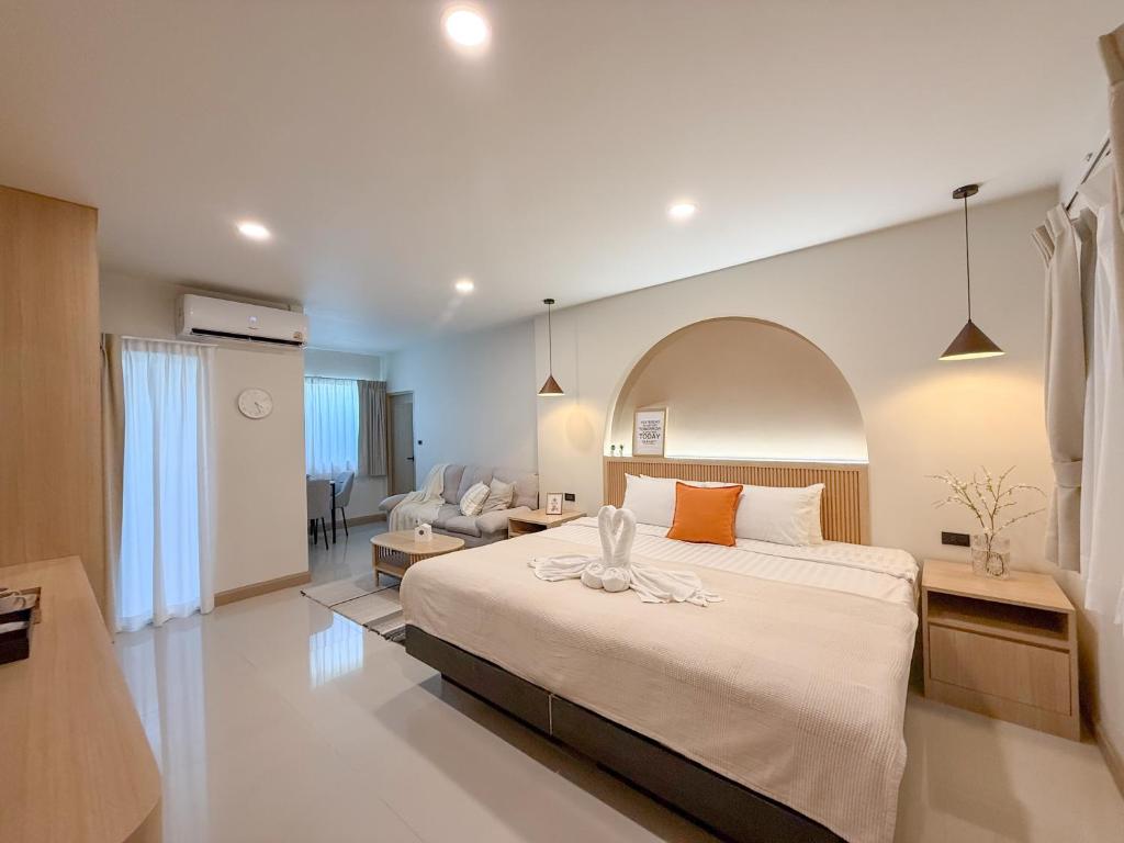 a bedroom with a large bed and a living room at Abundant Eco Hostel in Laguna Phuket