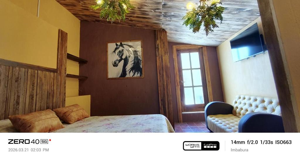 a bedroom with a bed and a picture of a horse on the wall at "De HugoS" hospedaje in Ibarra