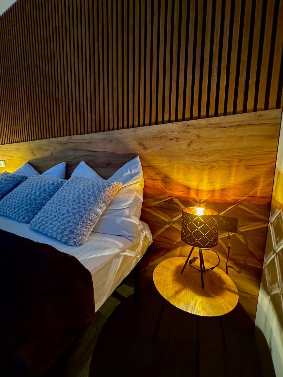 a bedroom with a bed and a table with a lamp at Too Apartment Lipno in Černá v Pošumaví