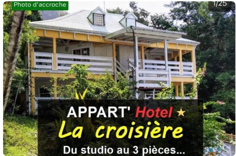 a sign in front of a large house at Appart'hotel La croisière in Gourbeyre