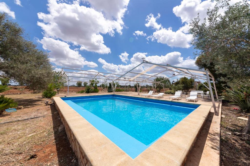 a swimming pool in a yard with chairs around it at Villa Oasis in Torre Lapillo