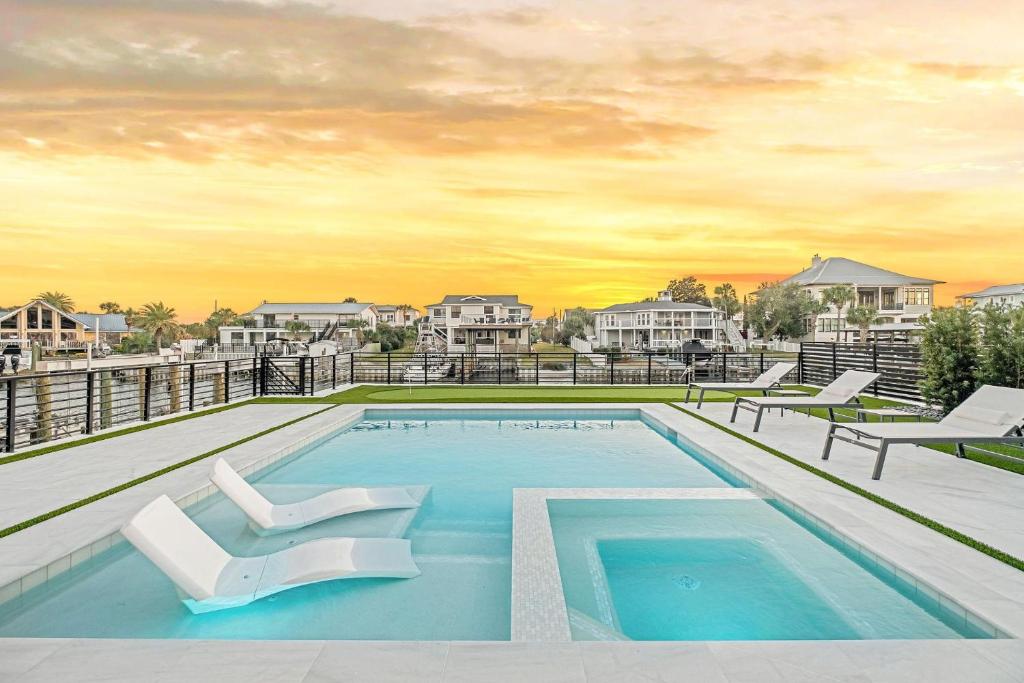 a swimming pool with two white chairs on top of a house at Isle Be Back in Destin