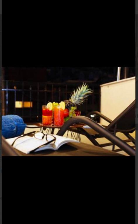 a table with two glasses and fruit on it at J&B Suites in Kavála