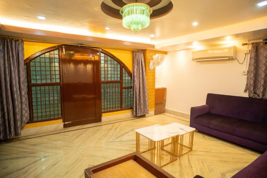 a living room with a purple couch and a table at The Tulsi Enclave Riverside in Agartala