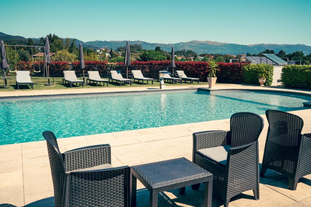 a group of chairs and a swimming pool at Casa d'Amares in Amares