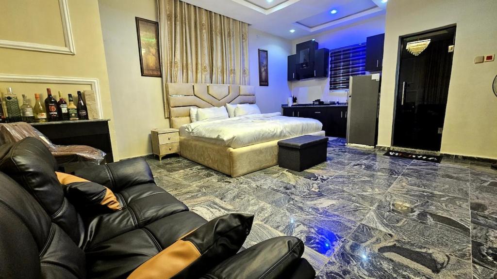 a bedroom with a bed and a couch in a room at Skye Palace Apartment - Ambassador Suite in Akure