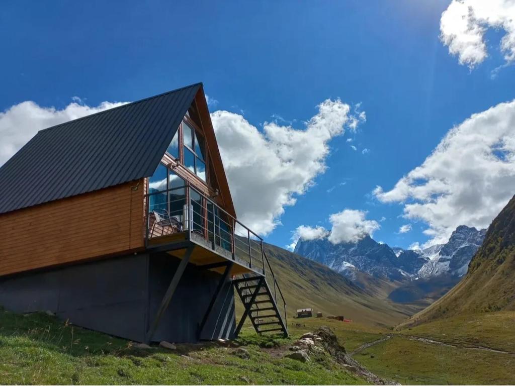 a house on top of a hill with mountains in the background at Cottage Hillside in Juta in Jut'a