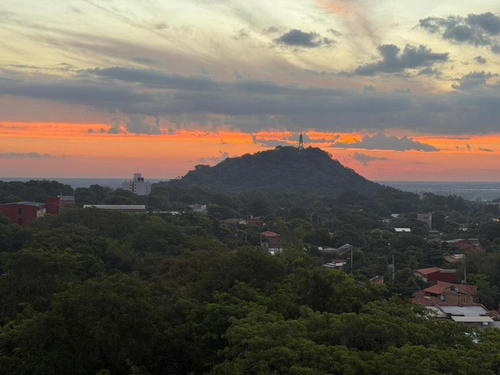 a view of a mountain with a sunset in the background at Premium Apartamento en Lambare in Asunción