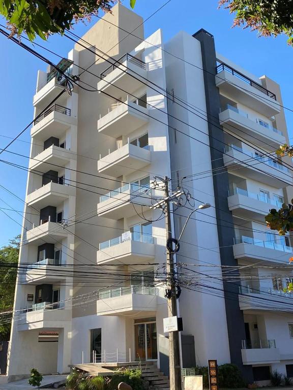 a tall white apartment building with balconies at Edificio Juan XXIII - 2 Dormitorios - Zona Shopping Del Sol in Asunción