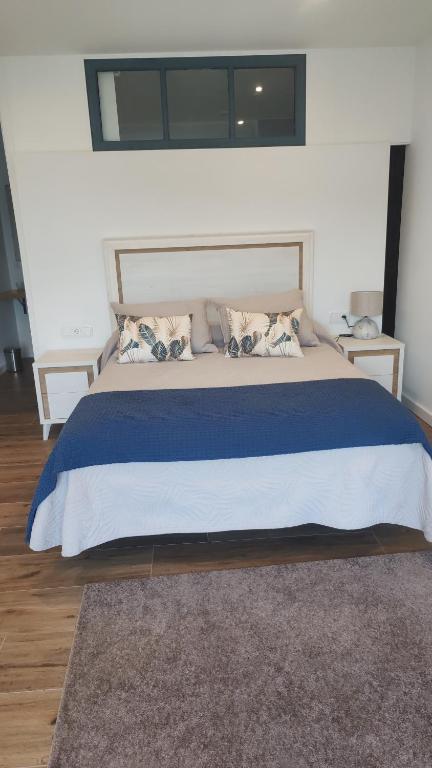 a bedroom with a large bed with a blue blanket at Olivo de Reis in Caldas de Reis