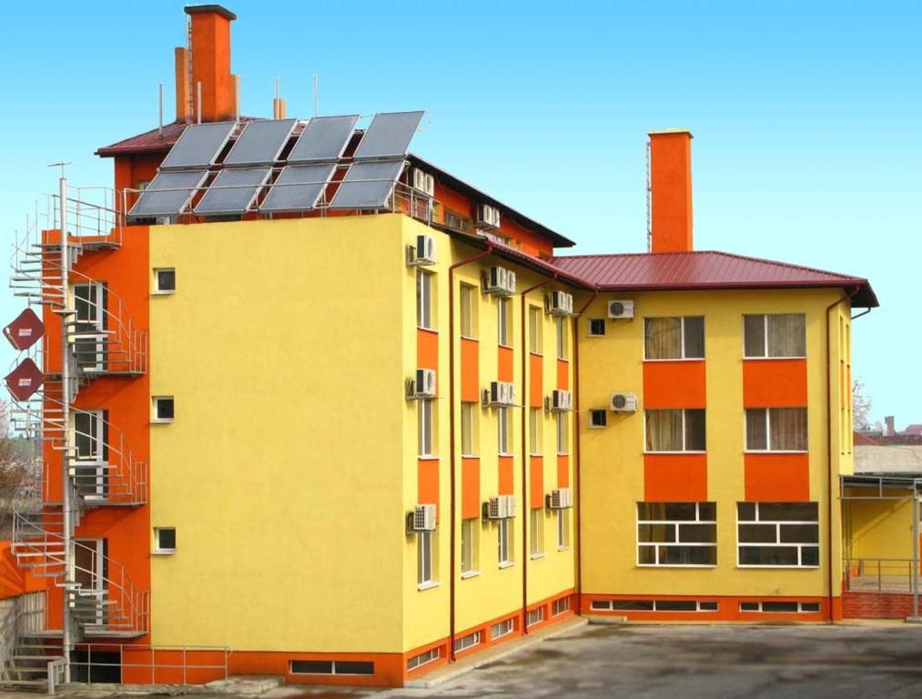 un edificio amarillo y naranja con paneles solares. en Hotel Nakra, en Radnevo