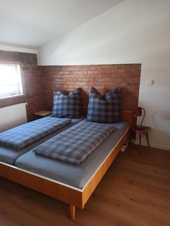 ein Bett in einem Zimmer mit einer Backsteinwand in der Unterkunft Auszeitbude Mudau, FeWo auf 48 m2 in Mudau