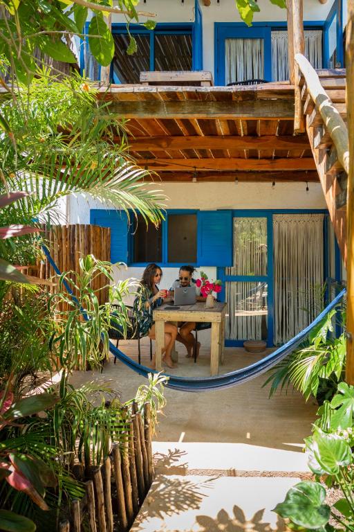 two people sitting at a table in front of a house at Casa Omero Garden in El Cuyo