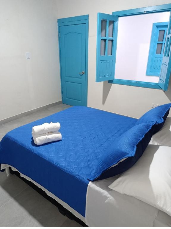 a blue bed with two towels on top of it at Quindio Mio in Filandia