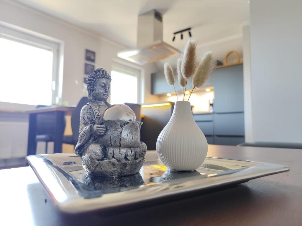 a tray with a statue and a vase on a table at Waldnest am Meer in Varel