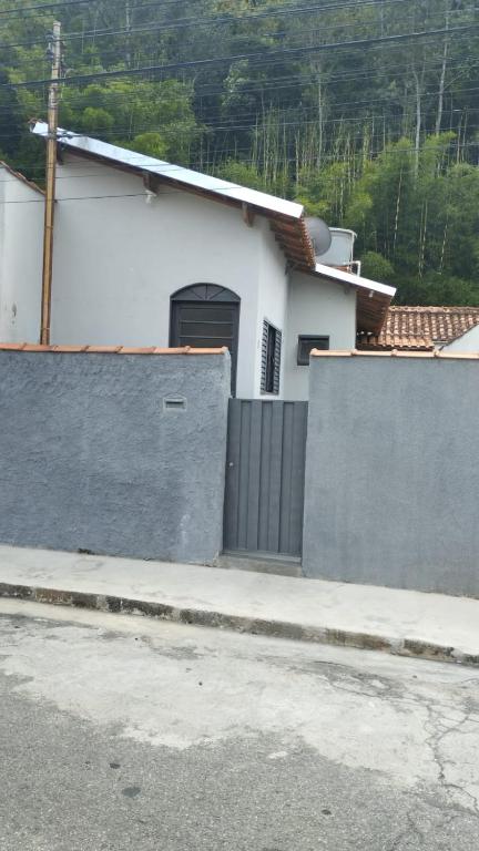 a white house with a garage and a fence at Casa Próxima ao Centro in Itajubá