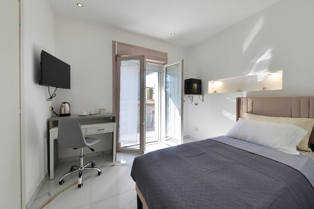 a bedroom with a bed and a desk and a computer at Gioia e Relax di ZR in Rho