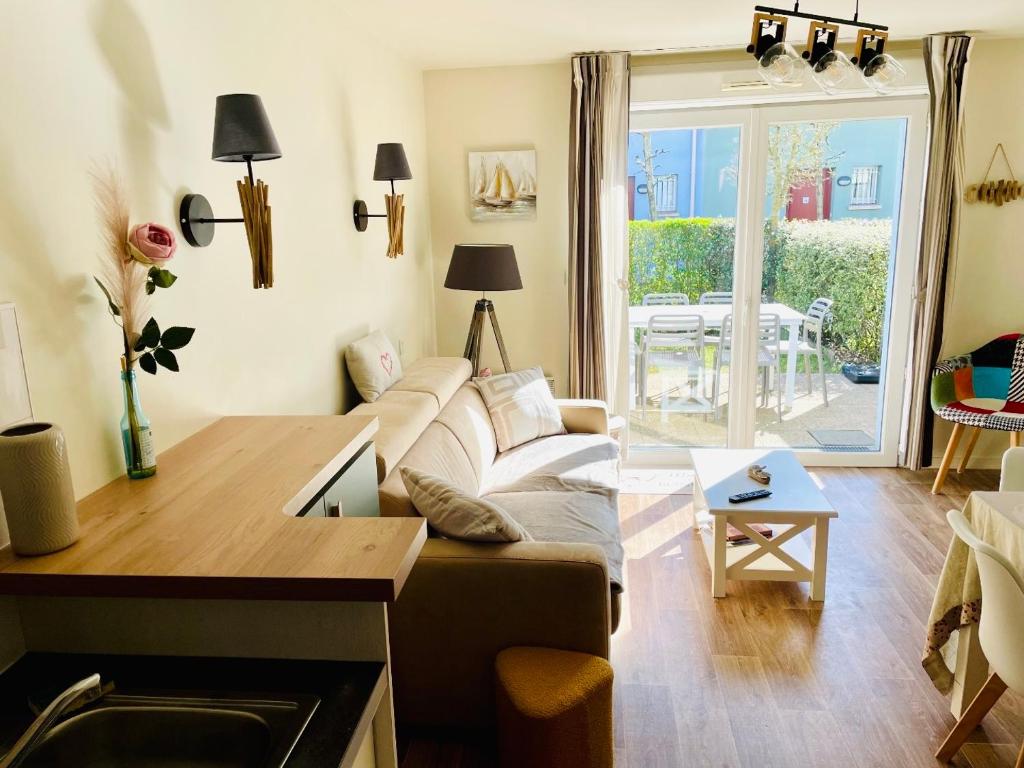 a living room with a couch and a table at Villa Chez Laurette - Baie de Somme en famille - 4 à 6 personnes - piscine - parking privé - plage à 5 min in Le Crotoy