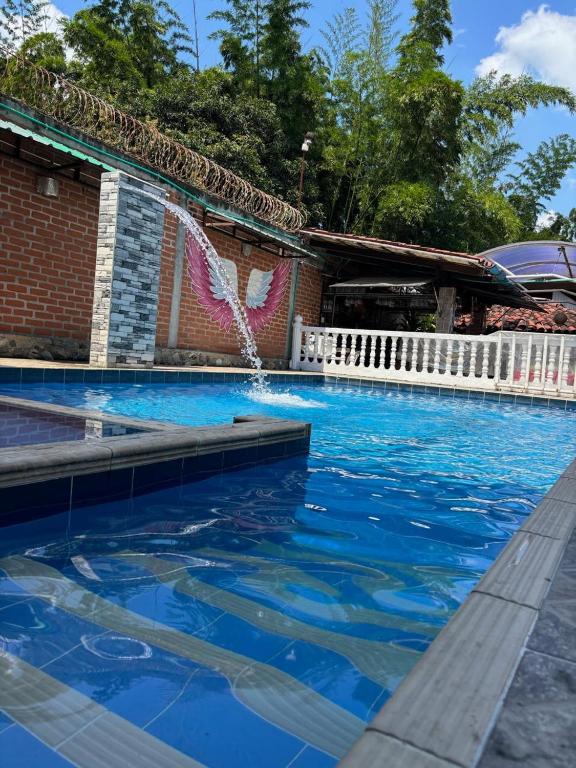 a swimming pool with blue water and a fountain at La morada in Guayabal