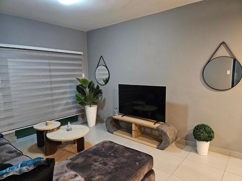a living room with a couch and a tv at Sky Apartment Mbabane CBD in Mbabane