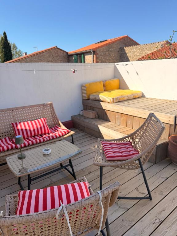 a patio with two chairs and a couch on a deck at La bodeguita terrasse in Saint-Génis