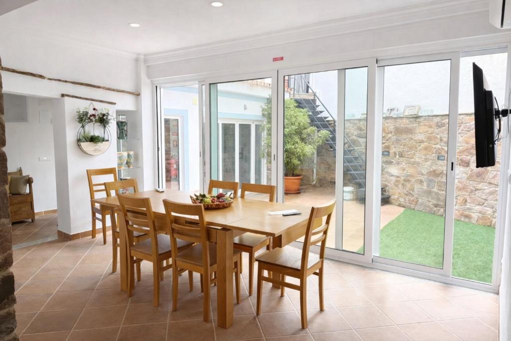a dining room with a wooden table and chairs at O Cantinho dos Avós in Mourão