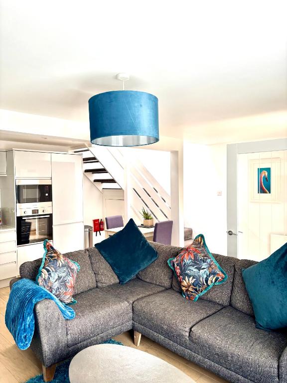 a living room with a gray couch with blue pillows at 1 Shiphouse Apartment in Lamlash