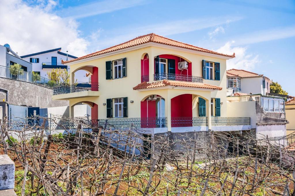 a house on the beach with red shutters at Villa Vineyard by Homie in Câmara de Lobos