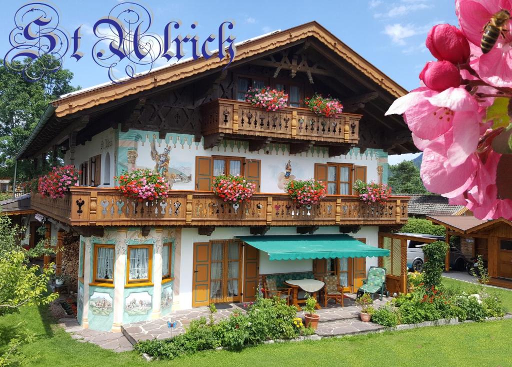 a building with a balcony with flowers on it at Ferienwohnung ZUGSPITZE in Krün