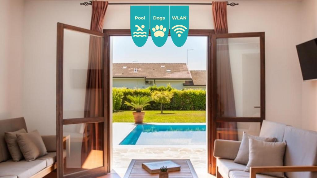a living room with a door open to a swimming pool at Villa Helena, Venetien, Exklusive Villa auf Privatinsel Albarella, 4 Bedrooms 8 Personen, 300 m Strand in Isola Albarella
