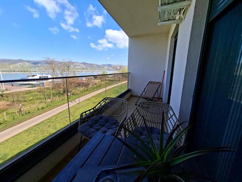 a balcony with two chairs and a view of the water at Silver Marina Residence in Veliko Gradište