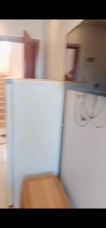 a white refrigerator in a room with a table at ريم الفلا in Dawwār Abū Maḩrūs