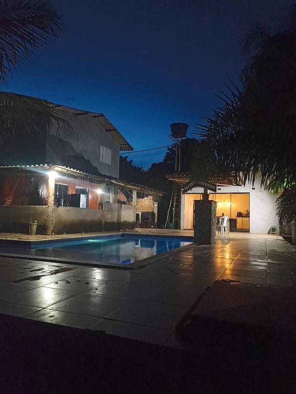 a swimming pool in front of a house at night at Recanto Chaparral in Aragoiânia