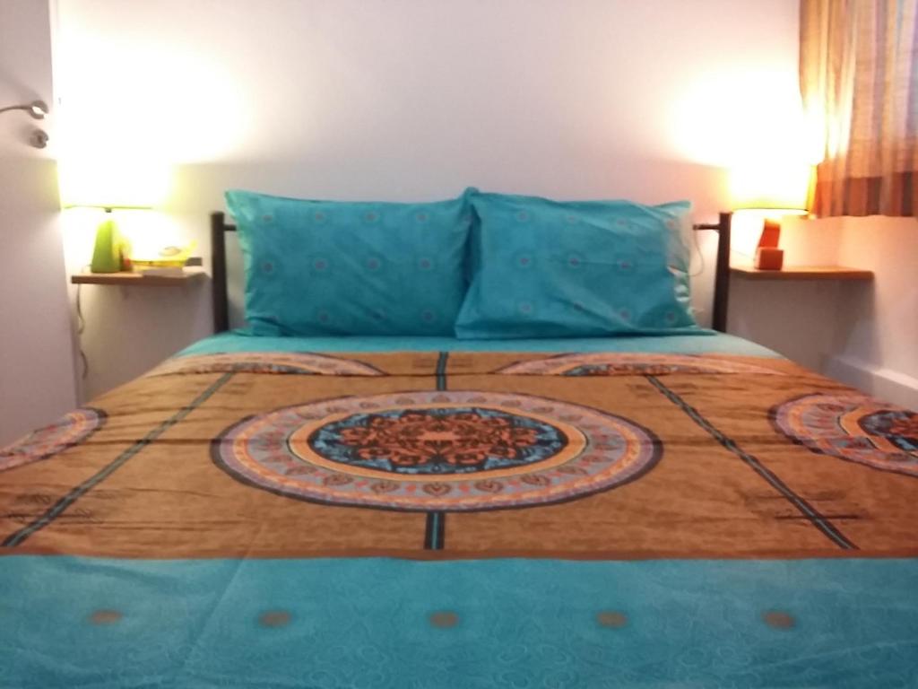 a bedroom with a bed with a blue comforter at Home in centre Mavromichali in Athens