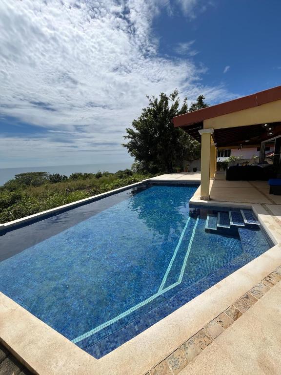 a swimming pool with chairs next to a house at Ballena Bay Villa Lot 45 Villa del Mar in Tambor