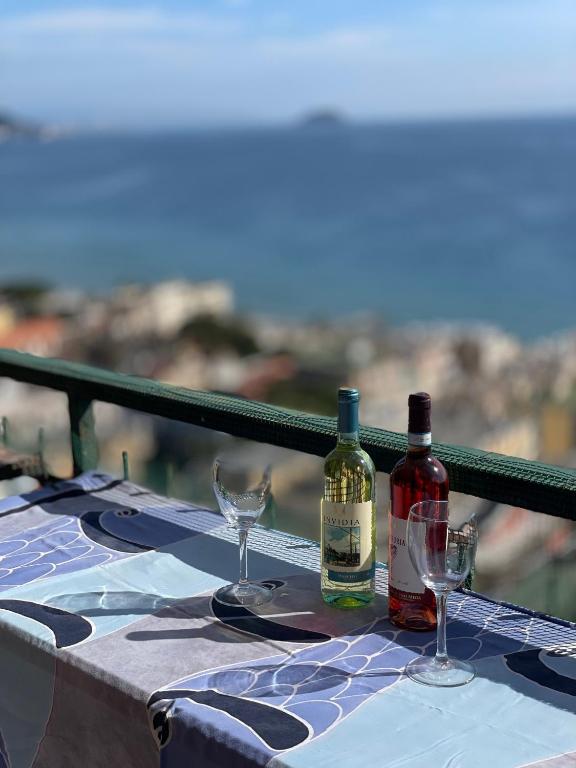 two bottles of wine and glasses on a table at Orizzonte guest house in Laigueglia