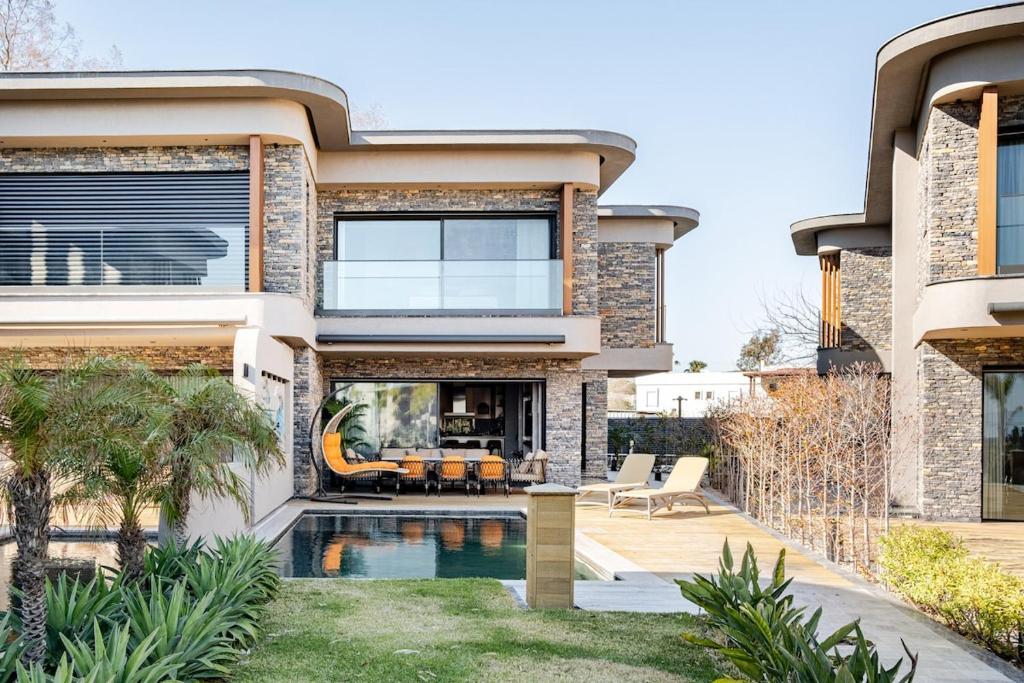a house with a swimming pool in front of it at Luxurious Villa Private Pool Private Beach Views in Bodrum City
