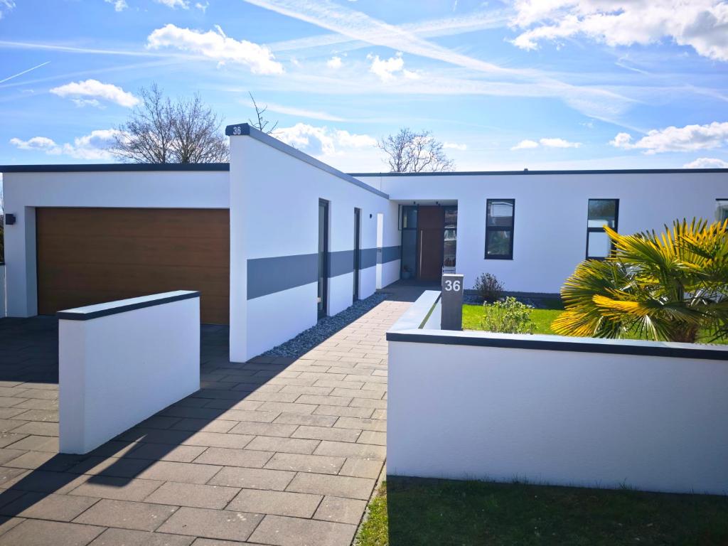a white house with a driveway at Nordloft Bad Nenndorf in Bad Nenndorf