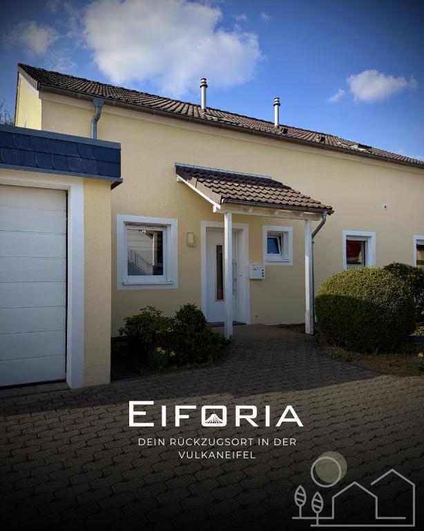 a house with a garage in front of it at Ferienhaus Eiforia in Gerolstein