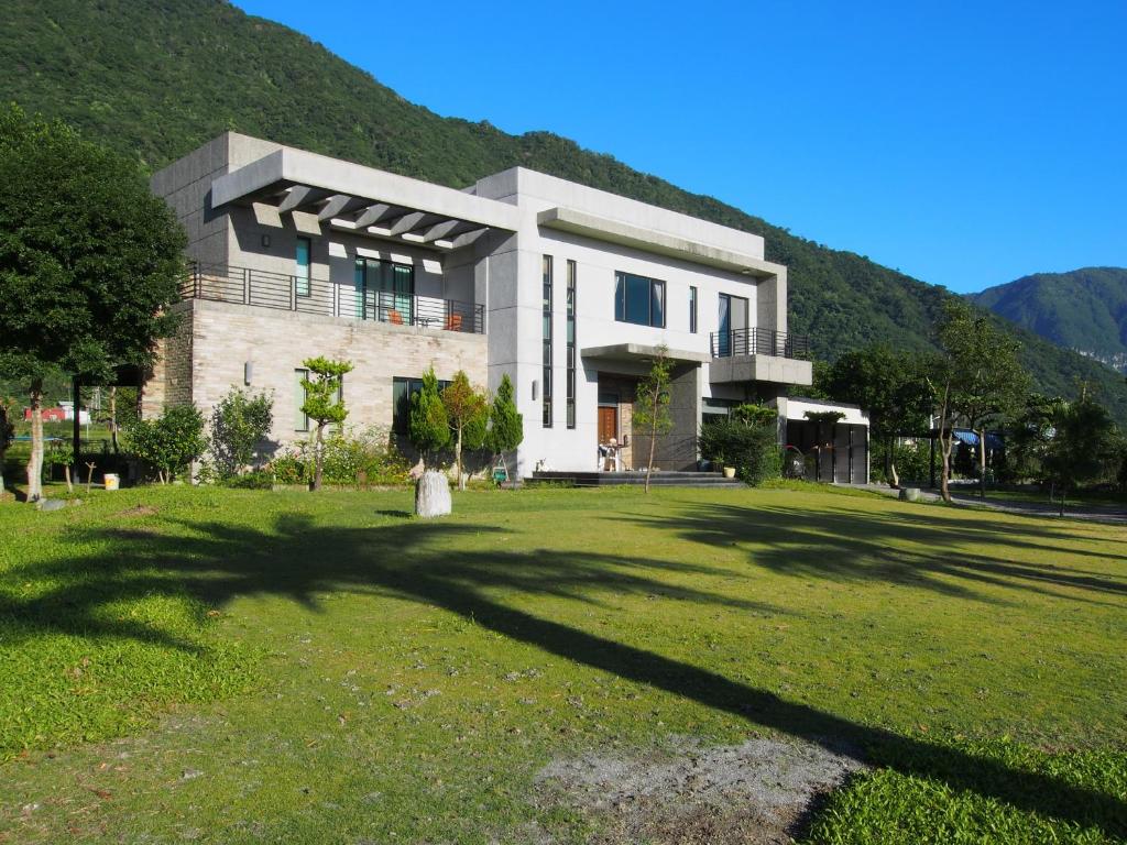 una casa grande con un gran patio frente a una montaña en Viasea B&B, en Xiulin