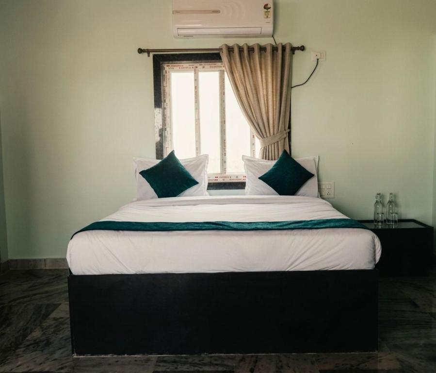 a bedroom with a large bed with a window at MMG Resorts in Nāspur