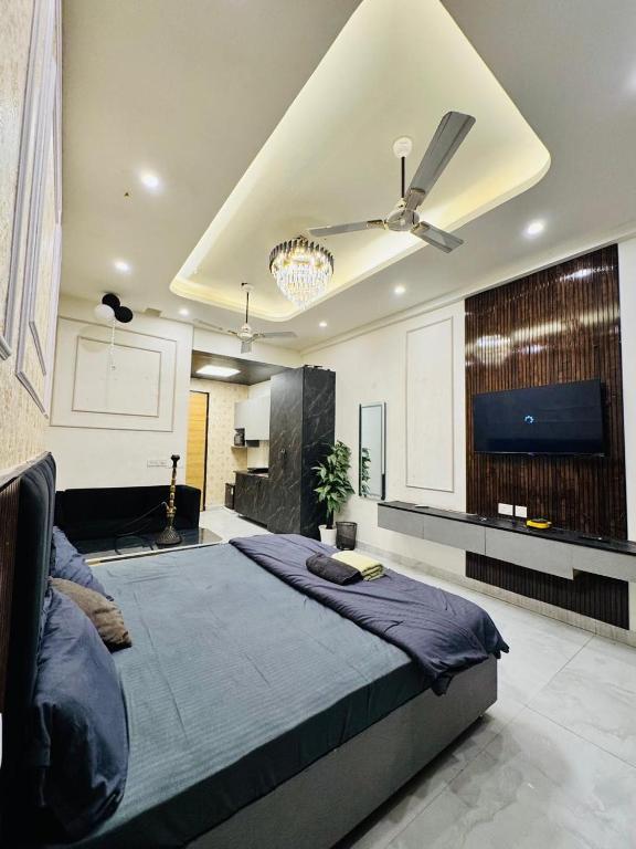 a bedroom with a large bed with a ceiling fan at The Skyline Studios in Ghaziabad
