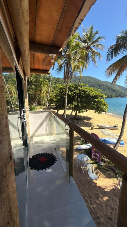 a balcony with a view of the beach and the ocean at Suítes Recanto dos papagaios in Angra dos Reis