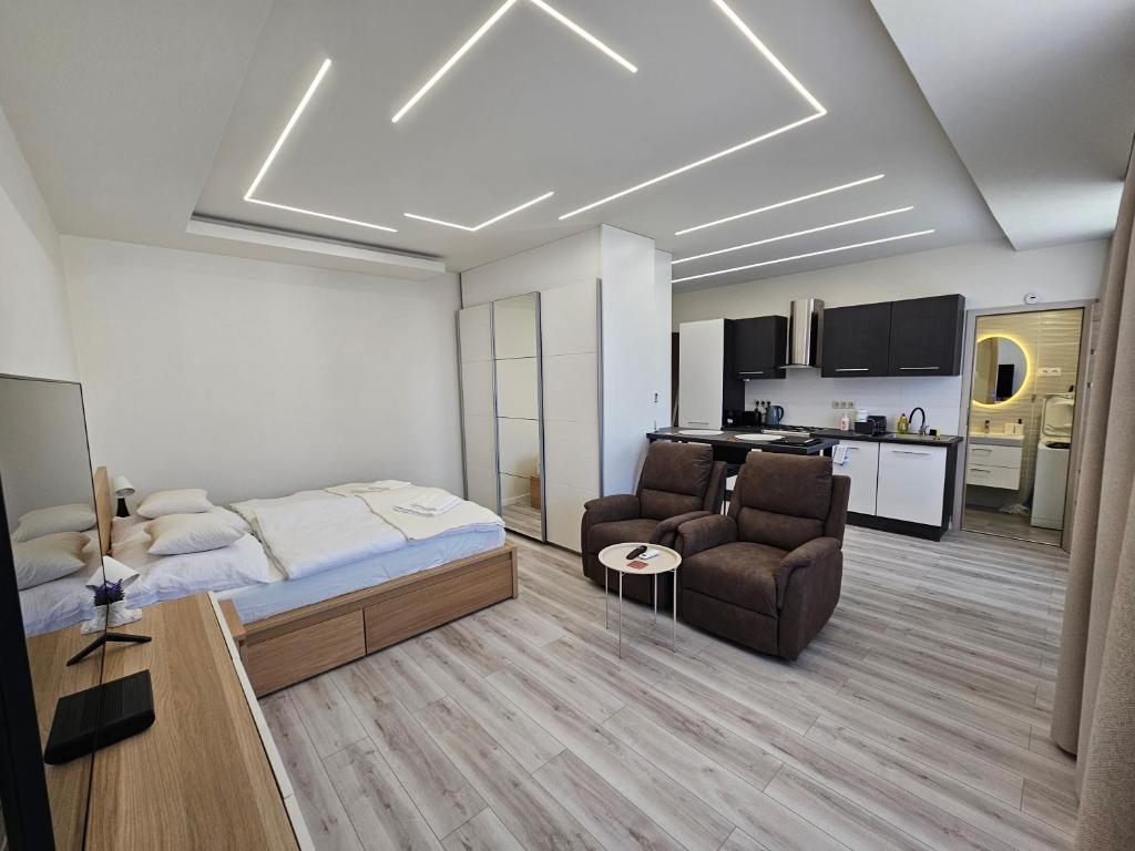 a bedroom with a bed and a living room at Barcika Prémium Stúdió in Kazincbarcika