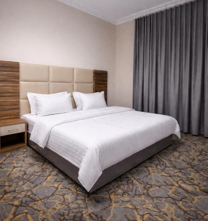 a bedroom with a large white bed in a room at شقــق فندقيـة in Hail